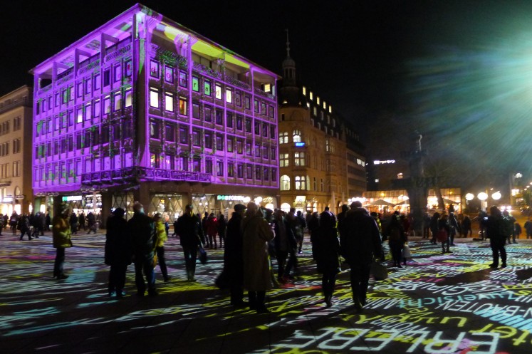 Die Installation verzichtet auf Leinwände, stattdessen dienen die umliegenden Gebäude und die Domplatte als Projektionsfläche.